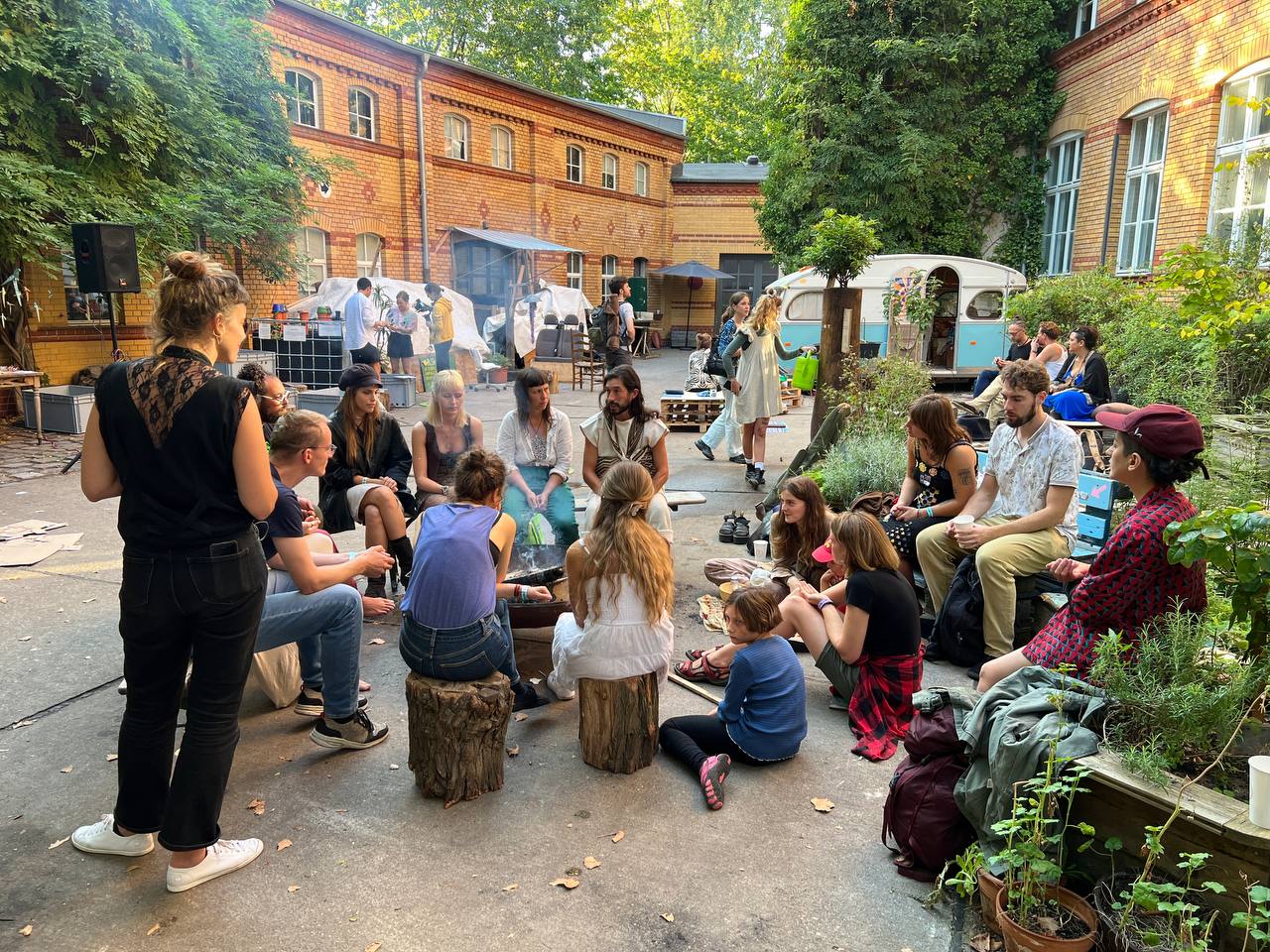 MOOS Berlin — communal gathering in the brick courtyard. Photo from the Supernuclear case study (guest post by Nicole Reese, Regen Tribe, 2023).