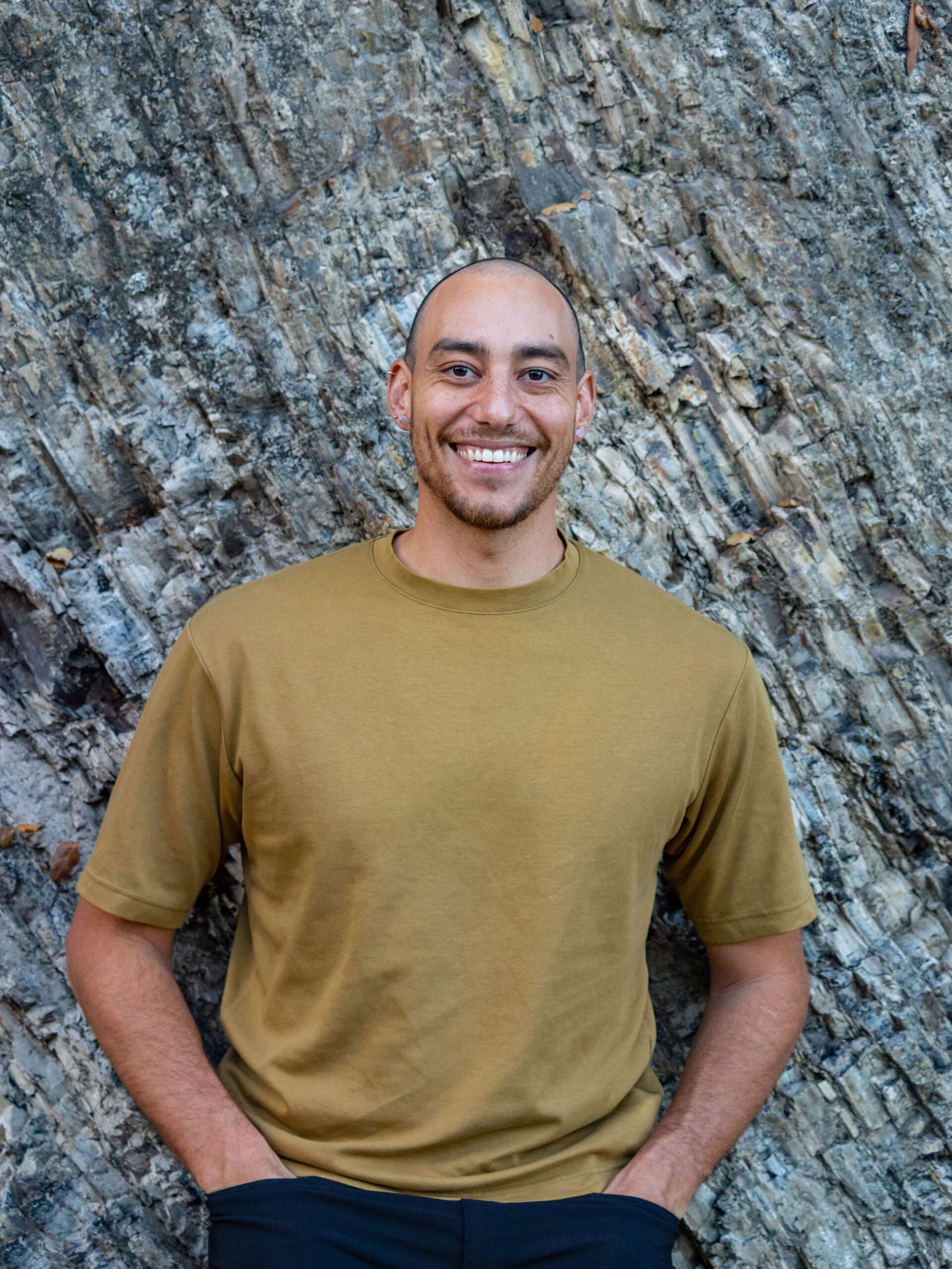 Bradley Clark Royes, full-length portrait, rock face